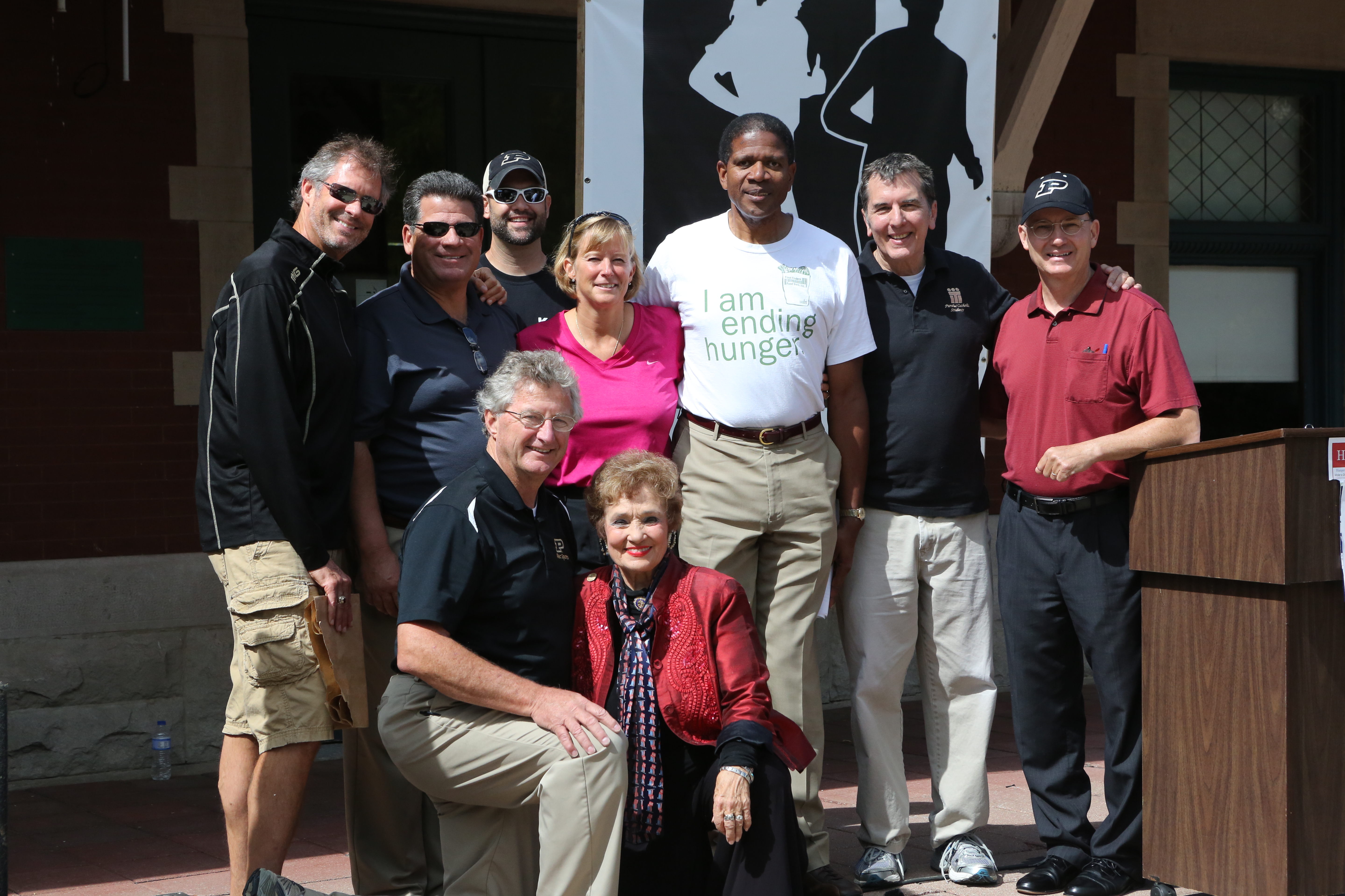 left to right, standing, are West Lafayette Mayor John Dennis, Lafayette Mayor Tony Roswarski, K105 Radio’s Shamus, Purdue Women’s Basketball Coach & Hunger Hike Co-chair Sharon Versyp, Gerald Thomas from Food Finders, Fr. Patrick Baikauskas from St. Thomas Aquinas Center, Joe Micon from Lafayette Urban Ministry; and in the front row: Purdue Crew Coach & Hunger Hike Co-chair Dave Kucik and Indiana State Representative Sheila Klinker. 